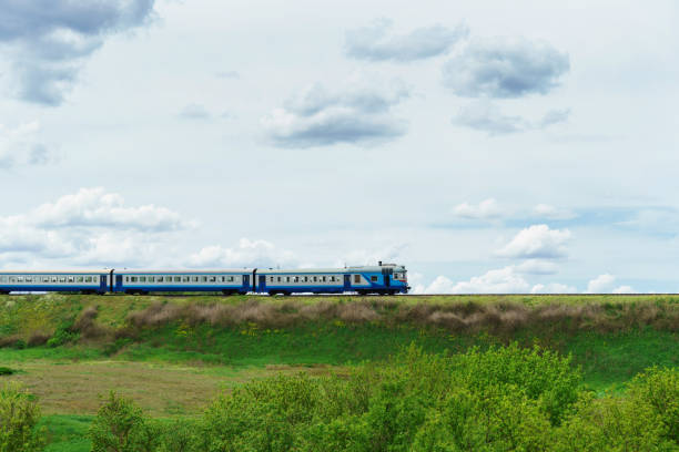 istock diesel train. blue passenger train rides on a track in the grass. 1318884929