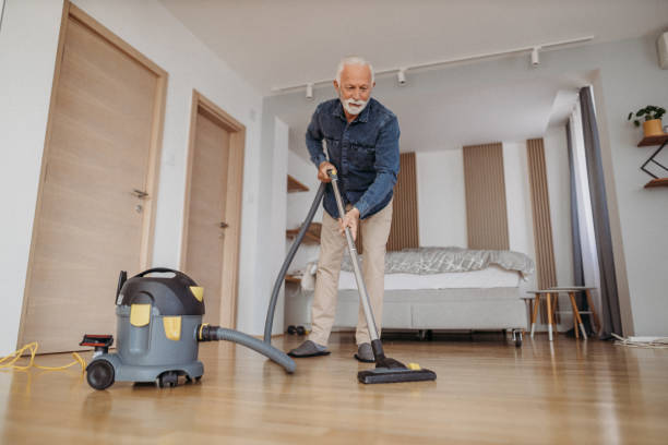 istock Senior man at home vacuum cleaning 1318885113