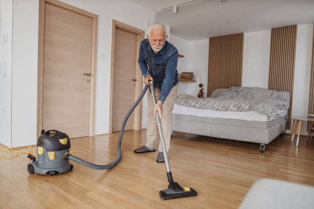 istock Senior man at home vacuum cleaning 1318885354