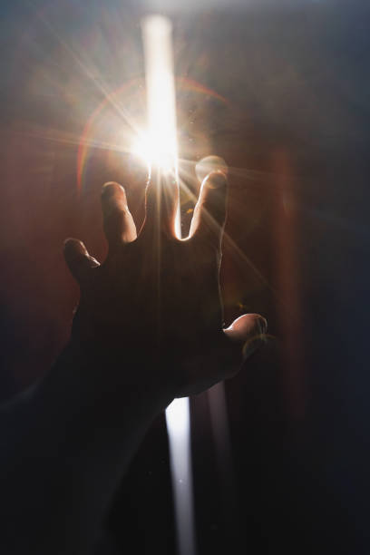 istock A hand reaching for a strip of light between the curtains. 1318886417