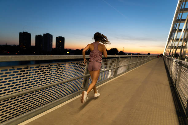 istock Young female athlete running on the bridge at dawn 1318887453