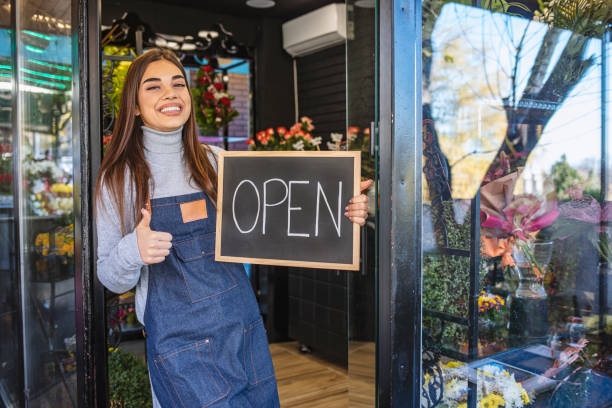 девушка приглашает в свой цветочный магазин. - owner florist sign business стоковые фото и изображения