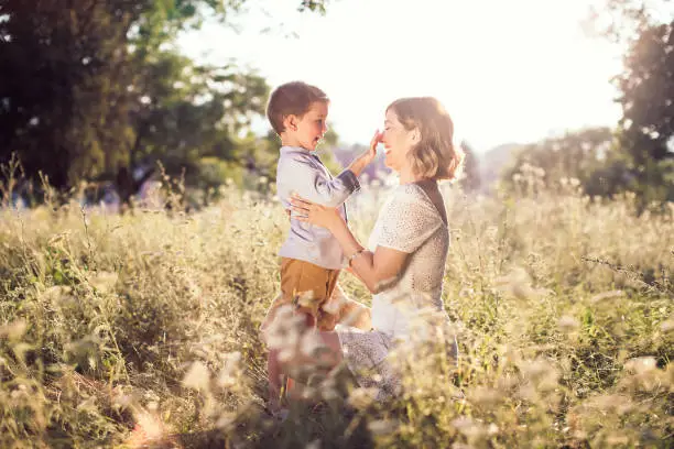 Photo of Beautiful young mom holding her blond son in her arms.. Mothers day