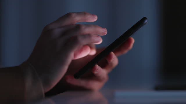 Close up of Male Hands Using Mobile Phone For Texting and Scrolling