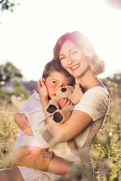 Photo of Beautiful young mom holding her blond son in her arms.. Mothers day