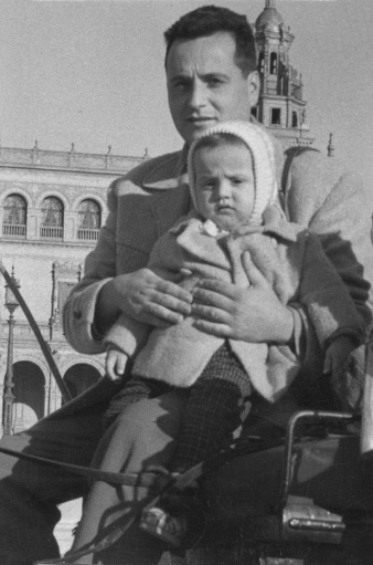 Vintage image from the 60s, young man sitting with his toddler boy in a horse carriage