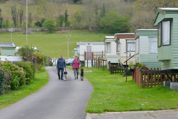 istock Couple walking their dogs around a caravan site with static caravans parked either side on a Spring day enjoying a vacation in rural Wales UK. 1318890764