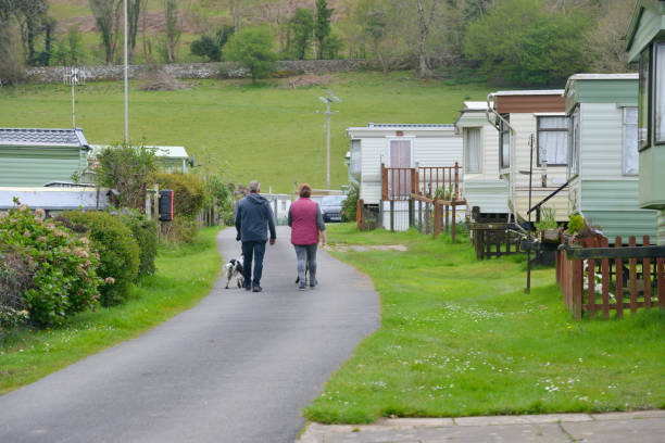 istock Couple walking their dogs around a caravan site with static caravans parked either side on a Spring day enjoying a vacation in rural Wales UK. 1318890765