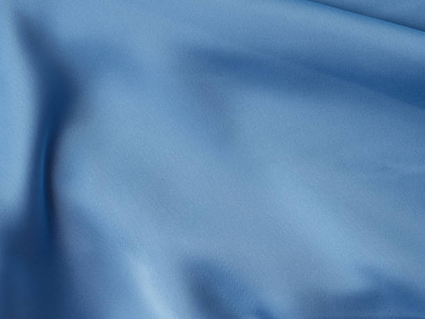 istock Blue satin texture background with waves and crease 1318893406
