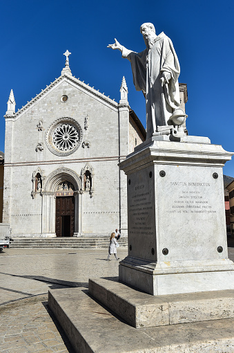 Italy Norcia 06.06.2015 Piazza san Benedetto with the statue of the saint and the basilica before the earthquake of 2016