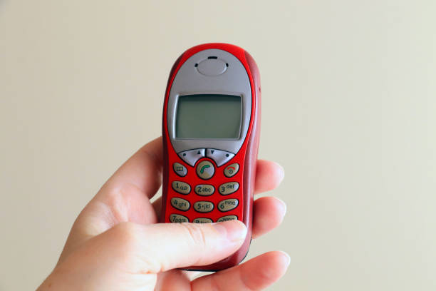 istock Woman holding old mobile phone 1318896330