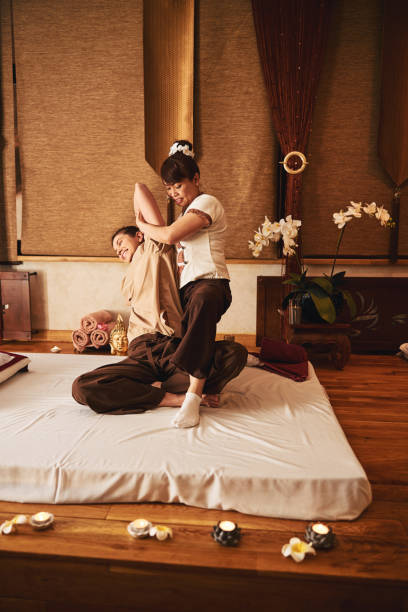 istock Smiling woman having her left arm stretched during Thai massage 1318897092