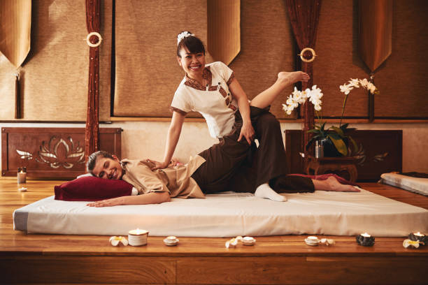 istock Practitioner of Thai massage throwing customer leg on her knee 1318897095