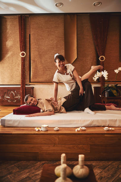 istock Thai female spa worker doing leg stretches for client 1318897096