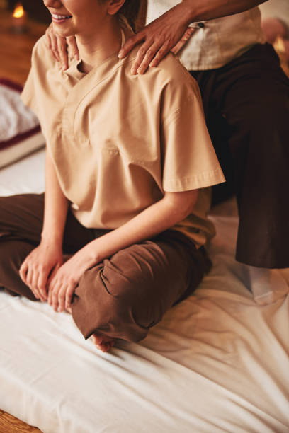 istock Hands massaging lady shoulders while she sitting on mat 1318897125