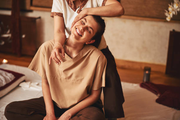istock Massagist tilting woman head while pressing elbow to her shoulder 1318897135