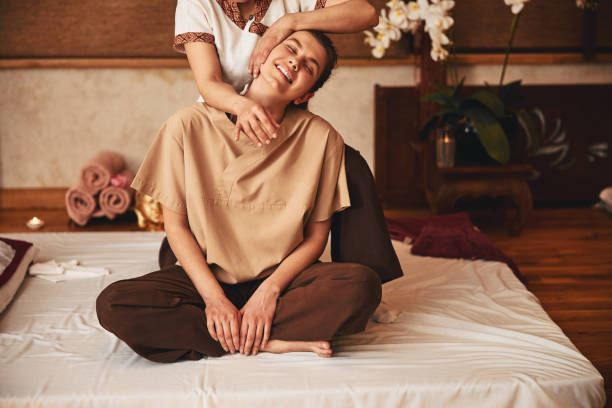 порадовала женщина, отдыхая под тайским массажем йоги - lotus spa treatment health spa women стоковые фото и изображения
