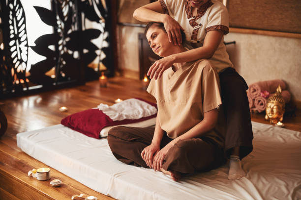 istock Massage professional tilting female client head to right 1318897154