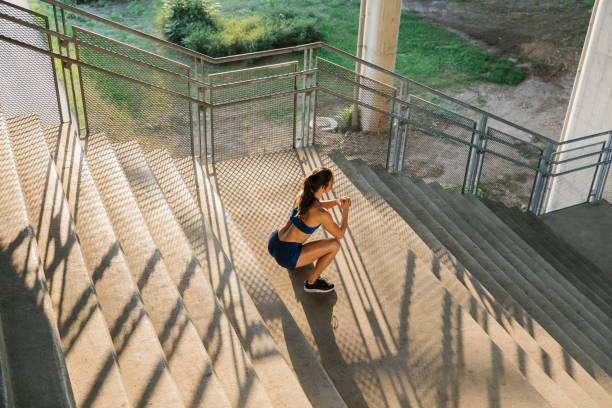 istock Woman doing squat exercise on the stairs 1318897905