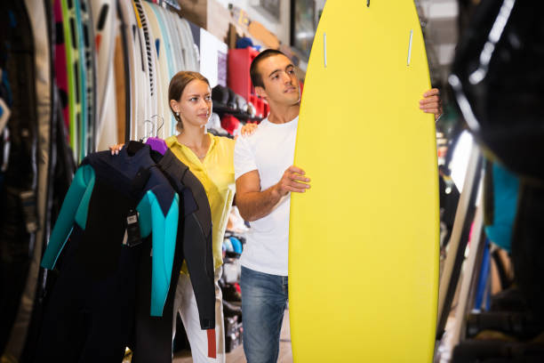 istock couple choosing surfboard in sporting goods store 1318898059