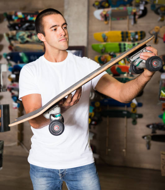 istock Man choosing skateboard in store 1318898084