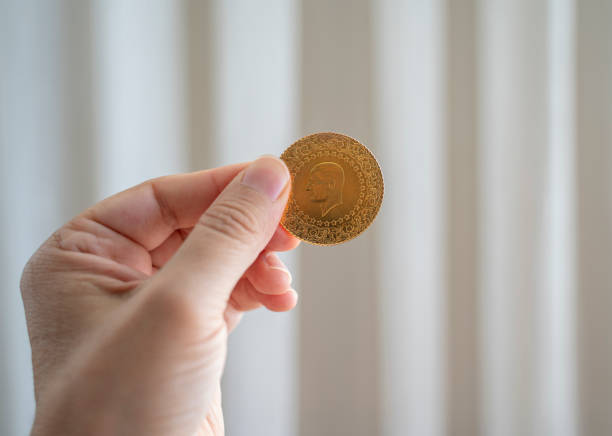 istock Hand holding Turkish gold coin, Close up 1318900321