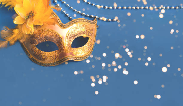 istock Carnival golden mask on blue background with silver beads. Mardi Gras concept. Copy space 1318904320