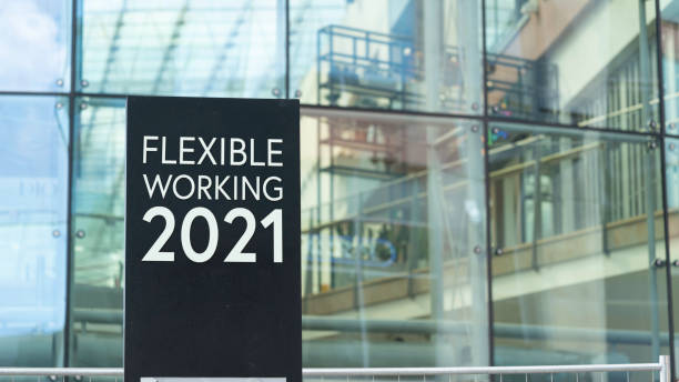 istock Flexible Working 2021 sign in front of a modern office building 1318905382