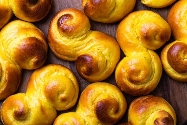 schwedische traditionelle weihnachtsbrötchen lussekatter oder lussebullar auf einem rustikalen holztisch hintergrund - lucia bun stock-fotos und bilder