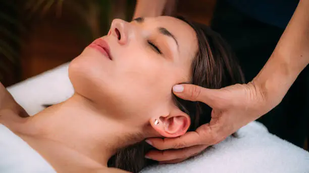 Photo of Cranial Osteopathy. Therapist Massaging Woman’s Head.