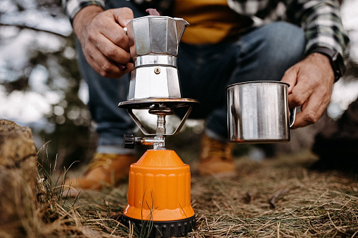 Mature man making coffee in nature