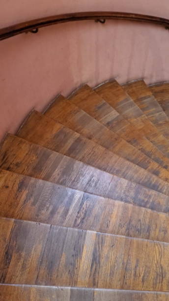 istock Old wooden spiral staircase with railing and shabby steps 1318914134