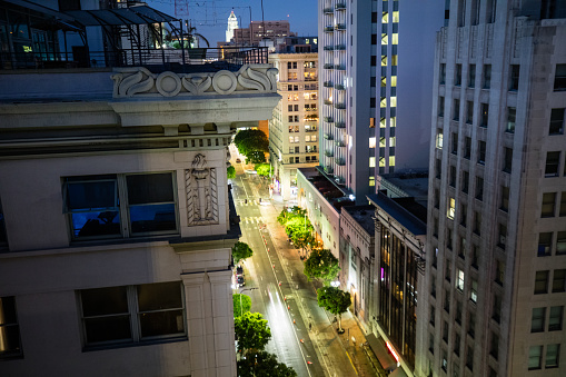View down of the 600 block of Spring Street in Downtown Los Angeles at sunset, with City Hall in the distance. Part of a sequence.
