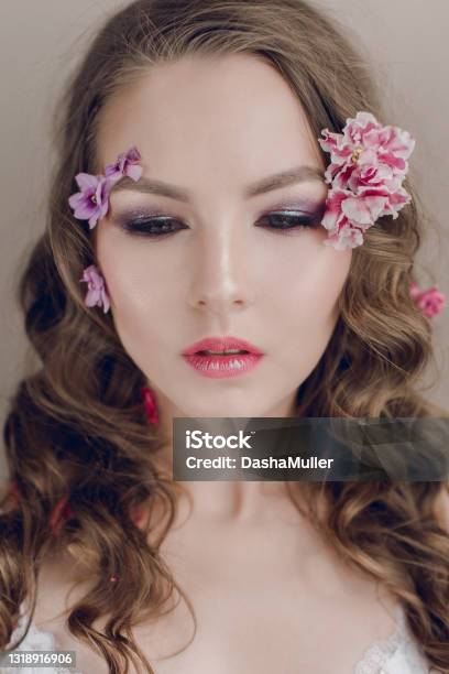 Cosmetics And Manicure Closeup Portrait Of Attractive Woman With Dry Flowers On Her Face And Hair Pastel Color Perfect Makeup And Skin On Blue Background Fresh Trendy Spring Retouched Portrait Stock Photo - Download Image Now