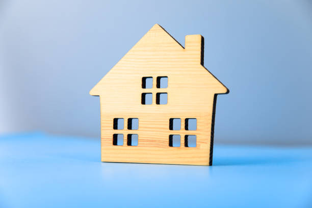 istock wooden house model on blue background 1318919479
