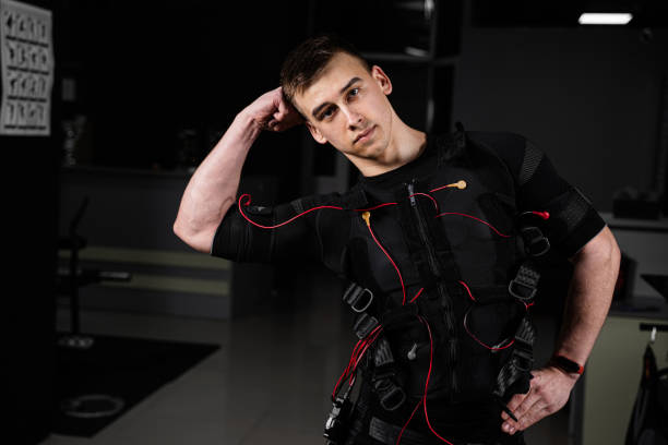 istock Making physical exercises using EMS suit in gym. Sport training in electrical muscle stimulation suit 1318921012