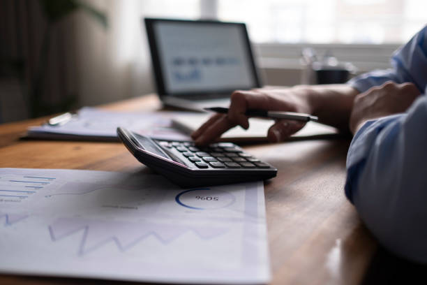 istock Business accounting concept, Business man using calculator with computer laptop, budget and loan paper in office. 1318926776