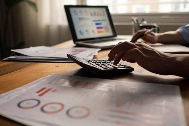istock Business accounting concept, Business man using calculator with computer laptop, budget and loan paper in office. 1318926823