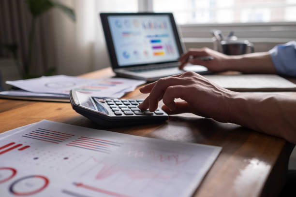 istock Business accounting concept, Business man using calculator with computer laptop, budget and loan paper in office. 1318926830