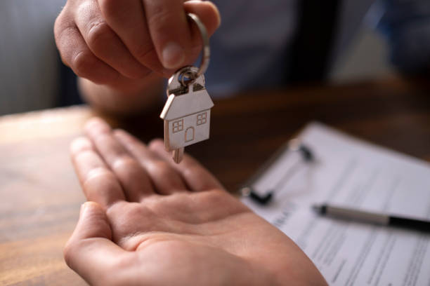istock Real estate agent passing keys to his client 1318926885