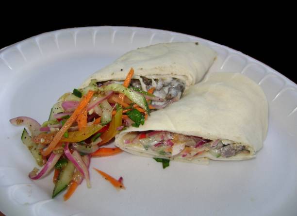 istock Big meat and vegetable burrito cut in half on a styrofoam plate 1318927874