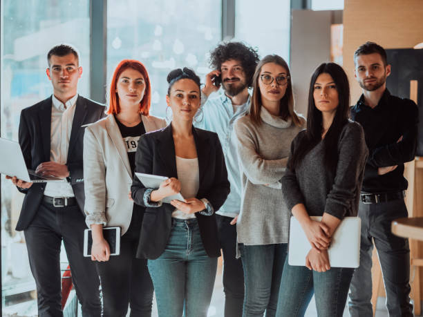 istock Young Smiling Managers Standing in Modern Office. Training in Office. Modern Office Concept. Woman in White Shirt. Man in Black Suit. 1318927988