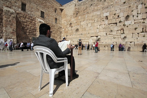 A Jewish man reads holy text near Jerusalem's Western Wall (Wailing Wall) - Jerusalem Old City, Israel