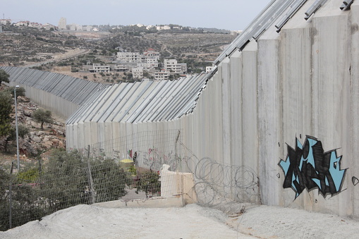 Graffiti on tall concrete wall that physically separates Palestinian territory (West Bank) and Israel - Bethlehem, Palestine