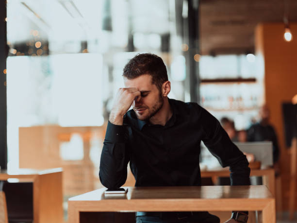 istock a tired businessman sitting in a cafeteria on a break from work. 1318929985