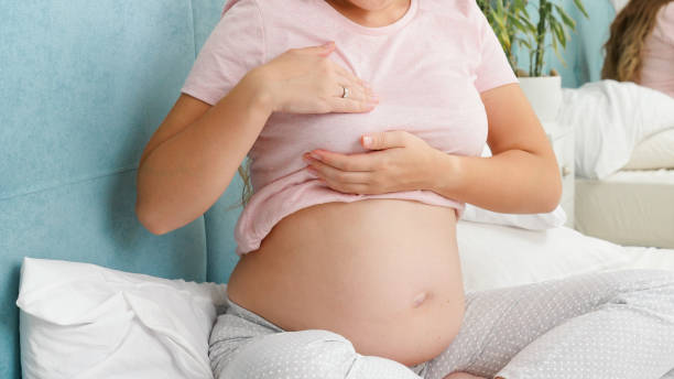 Young pregnant woman with big belly checking and touching her breast before lactation. Concept of pregnancy healthcare and medical examination Young pregnant woman with big belly checking and touching her breast before lactation. Concept of pregnancy healthcare and medical examination. pregnancy lactation stock pictures, royalty-free photos & images