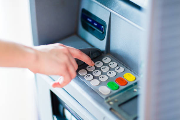 istock Closeup of hand entering PIN code into an ATM bank machine. 1318936014