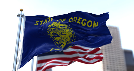 Las banderas del estado de Oregón y Estados Unidos ondeando al viento photo