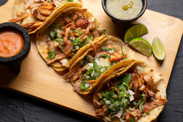 istock Pork tacos called al pastor with pineapple on dark background. Mexican tacos 1318944370