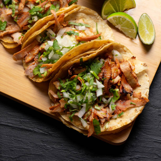 istock Pork tacos called al pastor with pineapple on dark background. Mexican tacos 1318944371